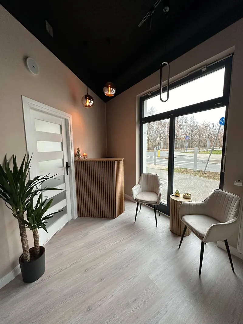 Poczekalnia salonu depilacji laserowej Simply Epil na Białołęce: dwa fotele, drewniana lada i duże okno